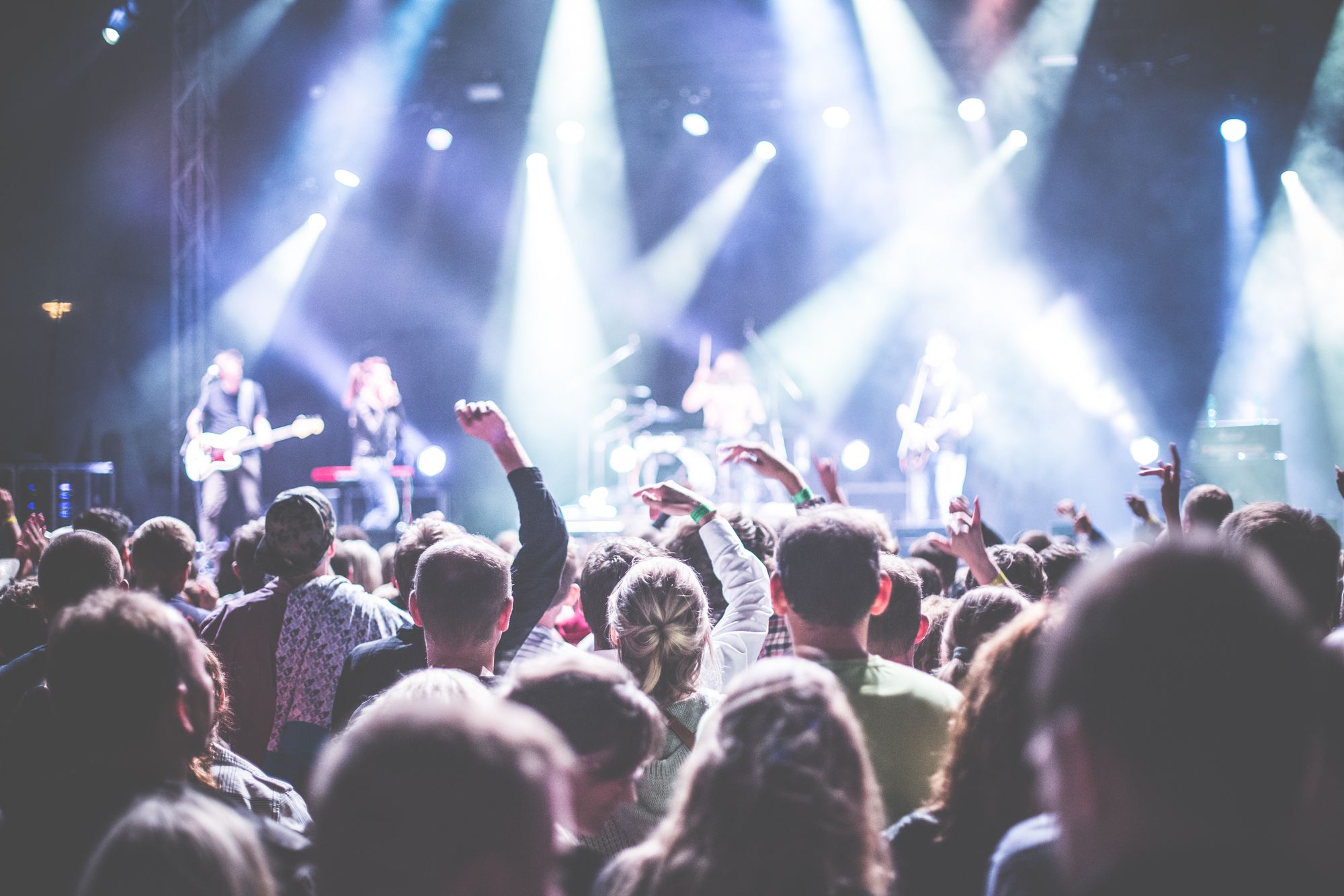 A packed outdoor festival crowd celebrating in front of a live stage
